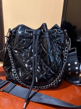 HAUTE SHORE Black Quilted Patent Drawstring Crossbody with Studded Strap
